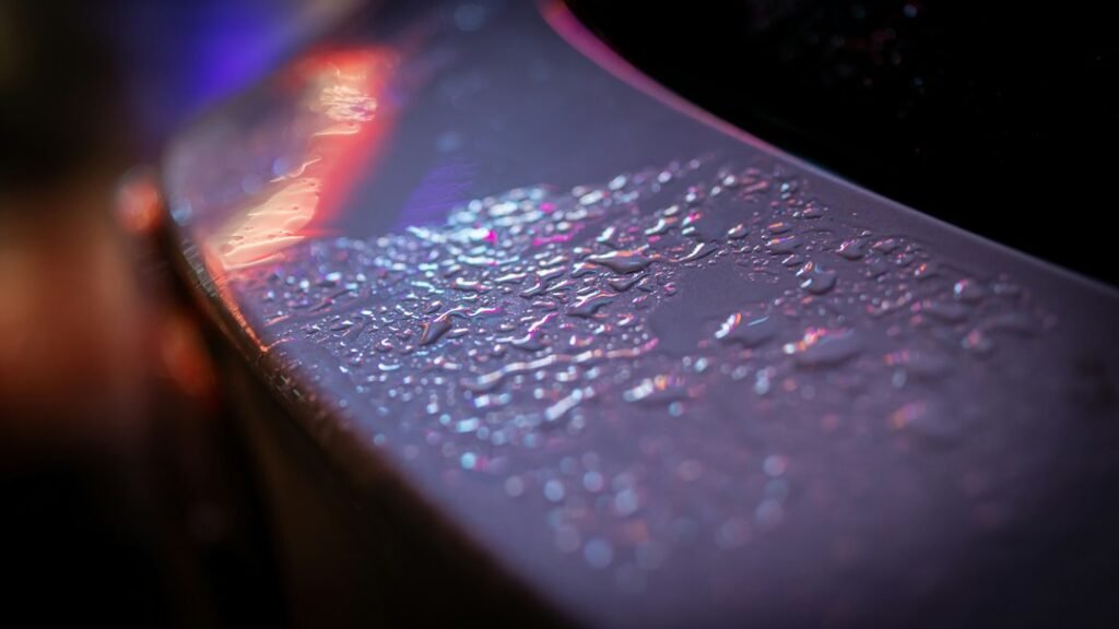 Water beading on a dark vehicle paint finish
